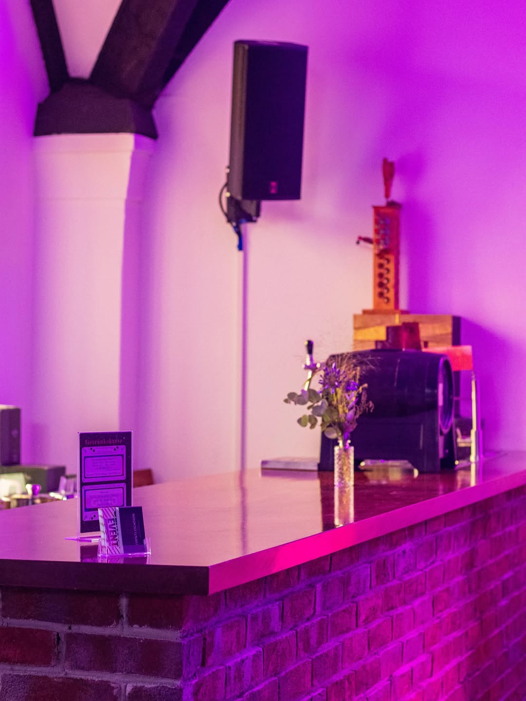 Barbereich mit Backsteinfront und stimmungsvoller violetter Beleuchtung